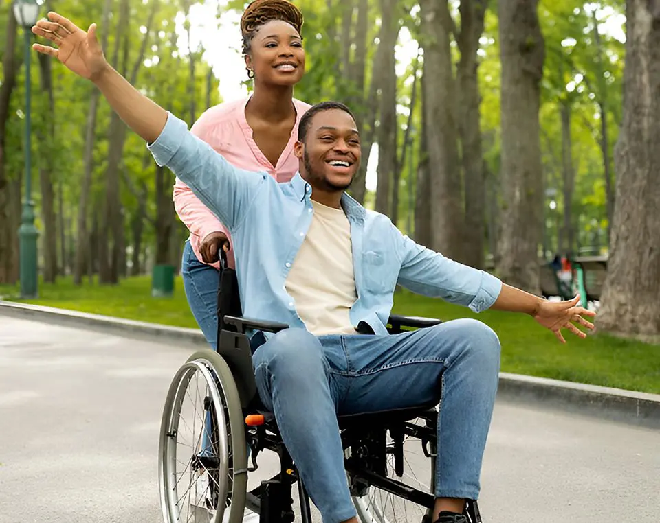 A man in a wheelchair with his arm outstretched.