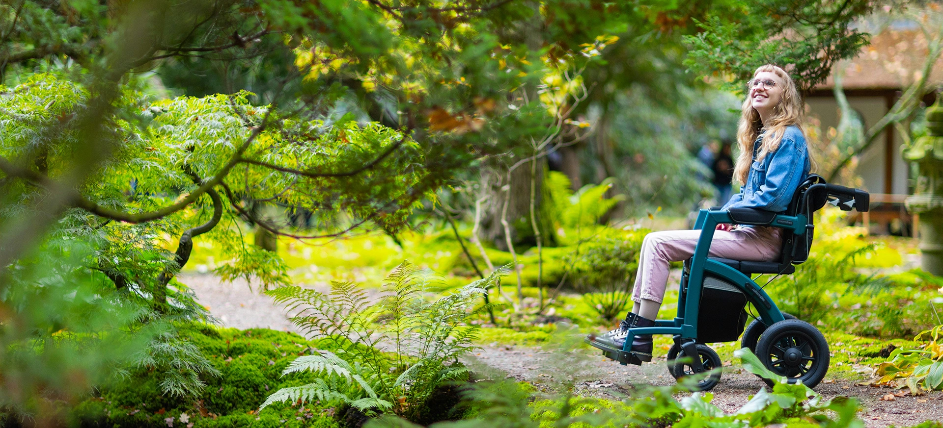 A person sitting on top of a bench in the woods.