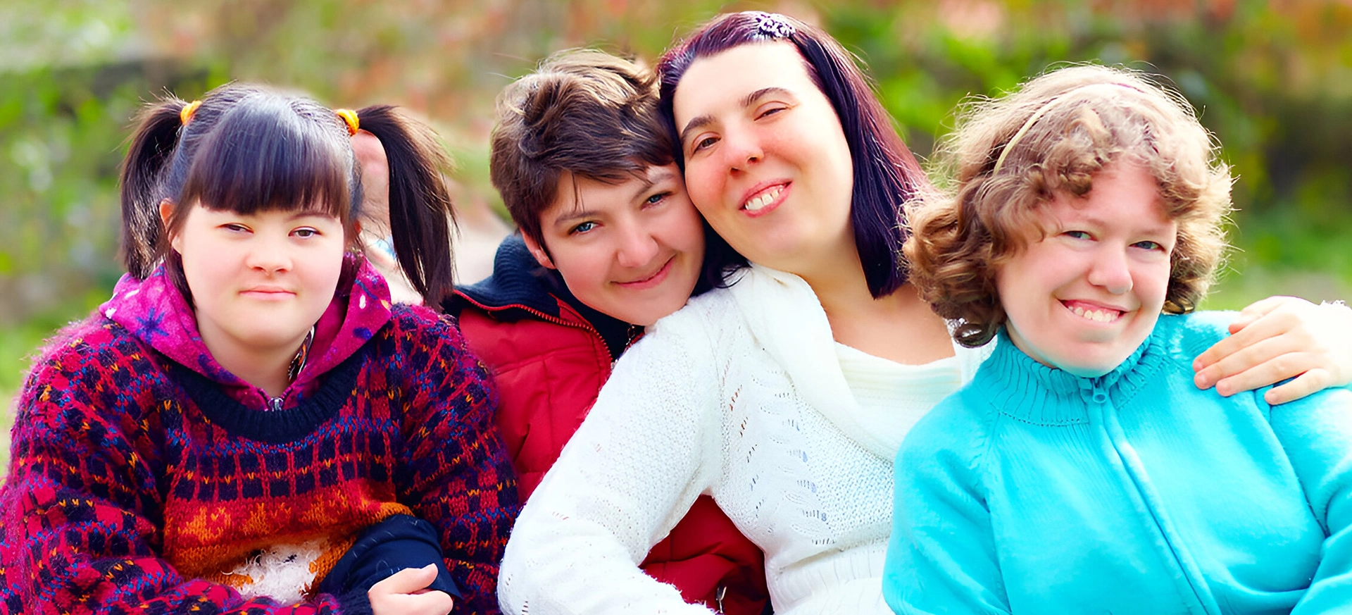 Two women hugging each other while others watch.